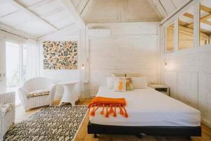 a bedroom with a large white bed in a room at Chanteak Bali in Jimbaran