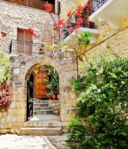 un edificio de piedra con una puerta de madera y escaleras en KASTRO AGGELIKI, en Kardhamili