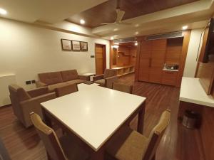 a living room with a white table and chairs at Ananth The Grand in Hubli