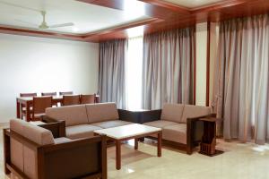 a living room with a couch and chairs and a table at Ananth The Grand in Hubli