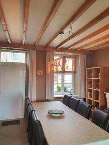 a dining room with a table and black chairs at Gîte du Soleil in Anhée