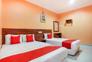 2 posti letto in una camera con rosso e bianco di My Town Hotel a Ipoh