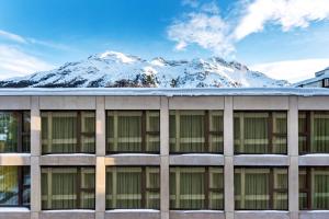 ein Gebäude mit einem schneebedeckten Berg im Hintergrund in der Unterkunft Townhouse N9 in St. Moritz