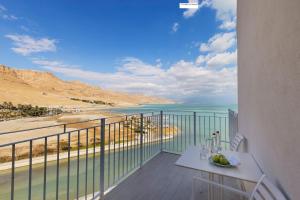 uma varanda com uma mesa e vista para o oceano em Herbert Samuel Hod Dead Sea Hotel em Ein Bokek