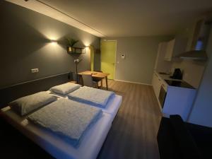 ein Schlafzimmer mit einem Bett und einem Tisch sowie eine Küche in der Unterkunft Short Stay Wageningen in Wageningen