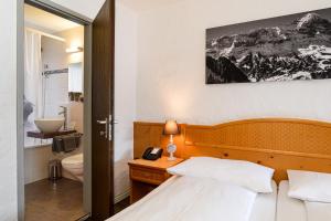 Pokój hotelowy z łóżkiem i łazienką w obiekcie Jungfrau Lodge, Annex Crystal w mieście Grindelwald