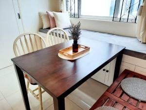 a wooden table with a vase on it in a room at 1 BR Cozy Farmhouse-Style Condo with Balcony & Taal View at Wind Residences in Tagaytay