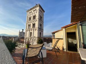 een balkon met stoelen en een klokkentoren bij Palazzo Rocchi - Residenza D'Epoca in Lucca