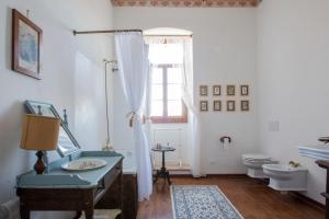 een badkamer met een wastafel, een toilet en een raam bij Villa Guarienti Valpolicella in Fumane