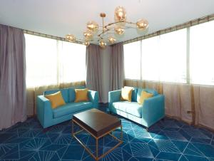 ein Wohnzimmer mit 2 blauen Stühlen und einem Tisch in der Unterkunft Swiss-Belhotel Napier in Napier