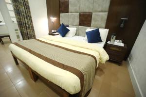 a hotel room with two beds with blue pillows at The Byke Heritage Adventure Park & Resort, Matheran in Matheran