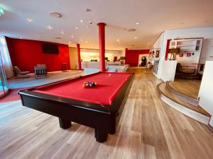 una sala de billar con una mesa de billar rojo en DORMERO Hotel Dresden City, en Dresden