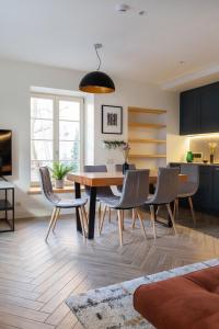 a kitchen and dining room with a table and chairs at Pilies Street Exclusive Apartment by Reside Baltic in Vilnius