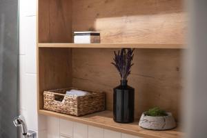 a black vase sitting on a shelf in a bathroom at Pilies Street Exclusive Apartment by Reside Baltic in Vilnius