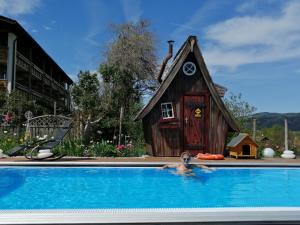 a person in a swimming pool in front of a house at Schlossberghof Marzoll in Bad Reichenhall