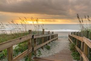 un camino de madera a la playa al atardecer en Snorkel Way, en Myrtle Beach