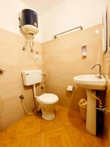 a bathroom with a toilet and a sink at Backpackers Headquarter Manali in Manāli