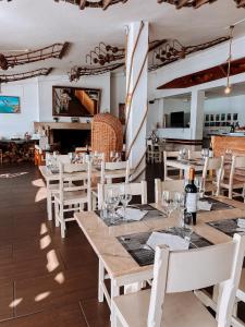 ein Restaurant mit weißen Tischen und weißen Stühlen und ein Zimmer in der Unterkunft Hotel HS Milfontes Beach - Duna Parque Resorts & Hotels in Vila Nova de Milfontes