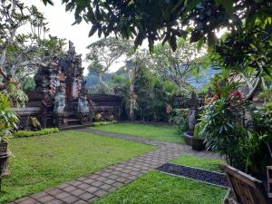 un jardín con un camino en el medio en Sahadewa House, en Ubud