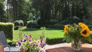 un jardín con flores en un jarrón sobre una mesa en Hof van Yde, en Yde