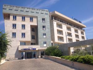 a large white building with a sign on it at Hotel Tiber in Fiumicino