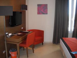 um quarto com uma secretária, uma cadeira e uma cama em Hotel Tiber em Fiumicino