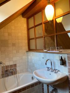 a bathroom with a sink and a tub and a mirror at CALLM aka Zum goldenen Löwen - zu Nacht bei der Destillerie in Kallmünz