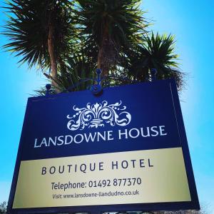 um sinal para um hotel louisbourgozy com palmeiras ao fundo em Lansdowne House with Private Car Park em Llandudno