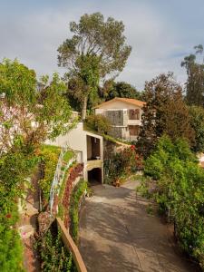 un jardin fleuri et une maison en arrière-plan dans l'établissement Mango Hill Kodai, à Kodaikānāl