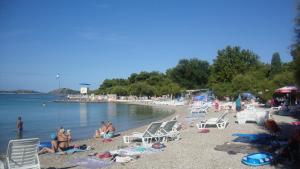 een groep mensen op een strand met stoelen en water bij Apartments Vodice Marica in Vodice