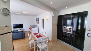 a kitchen with a table and a black refrigerator at Geräumiges und Modernes Apartment Tara am Meer mit Parkplatz! in Zandvoort