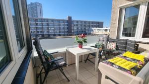 a balcony with a table and chairs on a balcony at Geräumiges und Modernes Apartment Tara am Meer mit Parkplatz! in Zandvoort