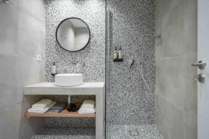 La salle de bains est pourvue d'une douche, d'un lavabo et d'un miroir. dans l'établissement Vagabond Guesthouse, à Athènes