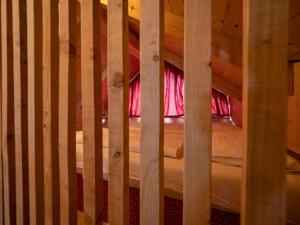 Bett in einem Holzbett mit rosa Vorhängen in der Unterkunft Chalet Sejalec in Lesce