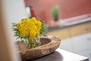 a vase filled with yellow flowers on a table at Oberglarzhof App Zirbel in Villnoss