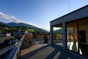 un balcón de un edificio con personas sentadas en sillas en Hotel Planai by Alpeffect Hotels, en Schladming