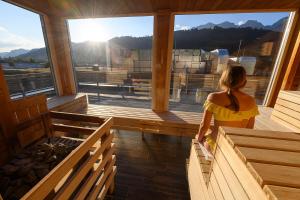 Una mujer con un vestido amarillo está mirando por la ventana de una iglesia. en Hotel Planai by Alpeffect Hotels, en Schladming