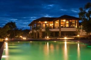 a villa with a swimming pool at night at The Serai Bandipur in Bandipūr