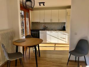 シャルメにあるAppartement 53m2 rénové dans un chalet au coeur de Charmey avec vue sur les montagnesのキッチン(テーブル、椅子付)