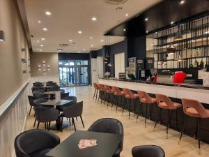 a restaurant with tables and chairs and a bar at D50 Hotel in Budapest