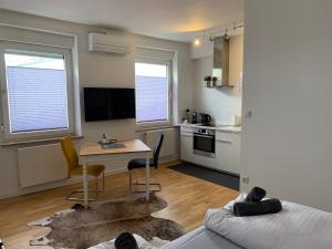 uma sala de estar com uma mesa e uma cozinha em Hotel Prinz Carl - Apartments mit Klimaanlage em Neckarsulm