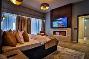 a bedroom with a large bed and a fireplace at Elexus Apartments Poiana Brasov in Poiana Brasov