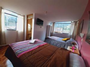 1 dormitorio con 2 camas y ventana en Hostal Raymi, en Ollantaytambo