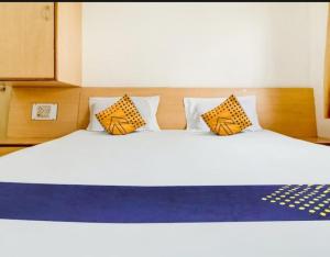 a bedroom with a large bed with yellow and blue pillows at Hotel Rahi in Nashik