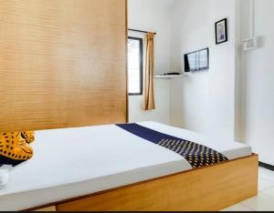 a bedroom with a bed with a wooden headboard at Hotel Rahi in Nashik