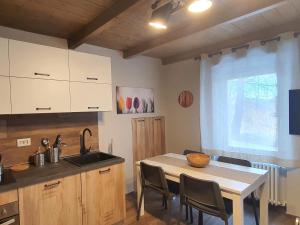 a kitchen with a sink and a table with chairs at Moda Apartments 01 in Sestriere