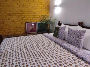 a large bed in a room with a brick wall at Mukam, Boutique Homestay in Jaipur