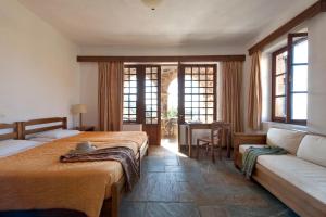 une chambre d'hôtel avec deux lits et un canapé dans l'établissement Kalamitsi Hotel, à Kardamyli