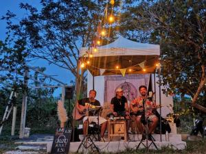 a group of three men sitting in front of a stage at DOX Ko Lanta in Ko Lanta