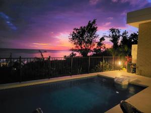 einen Pool mit Sonnenuntergang im Hintergrund in der Unterkunft -Villa Rikyu- 離宮 in Miyako-jima